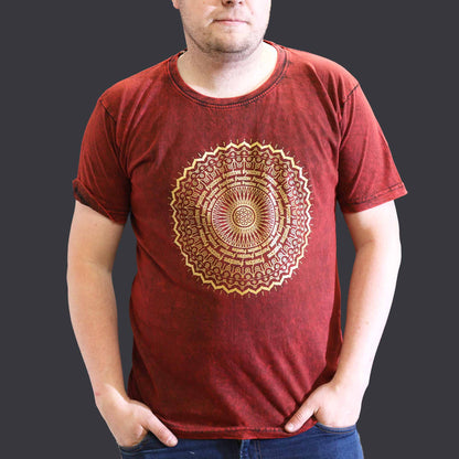 Man wearing a red t-shirt with a gold mandala design on a plain background