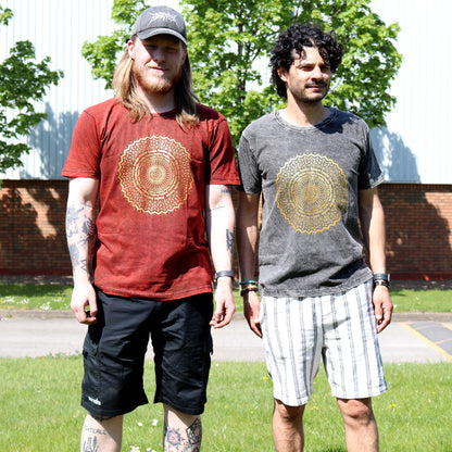 Two people wearing t-shirts with a gold mandala design outdoors.