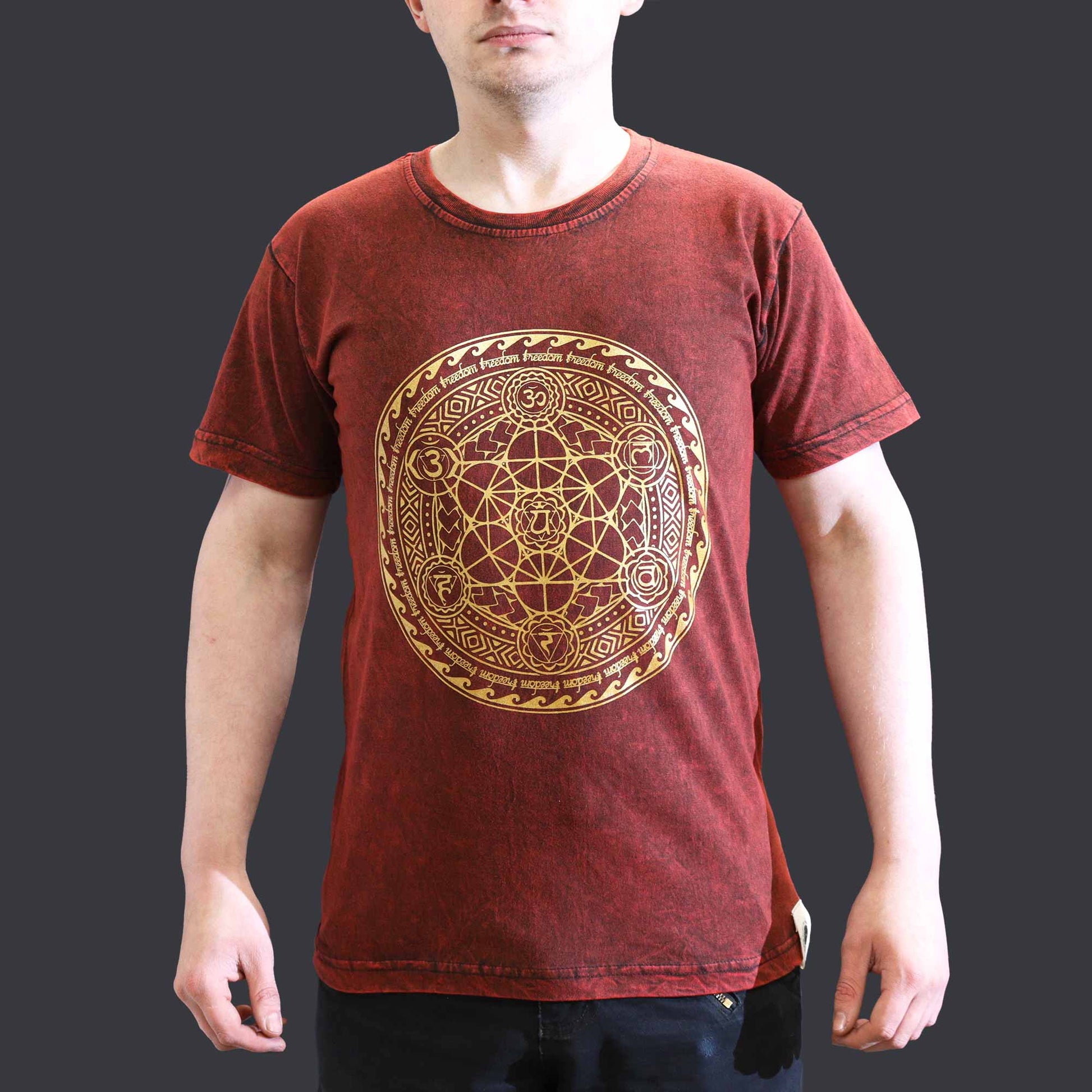 Red t-shirt with gold geometric  Chakra design worn by a person on a dark background