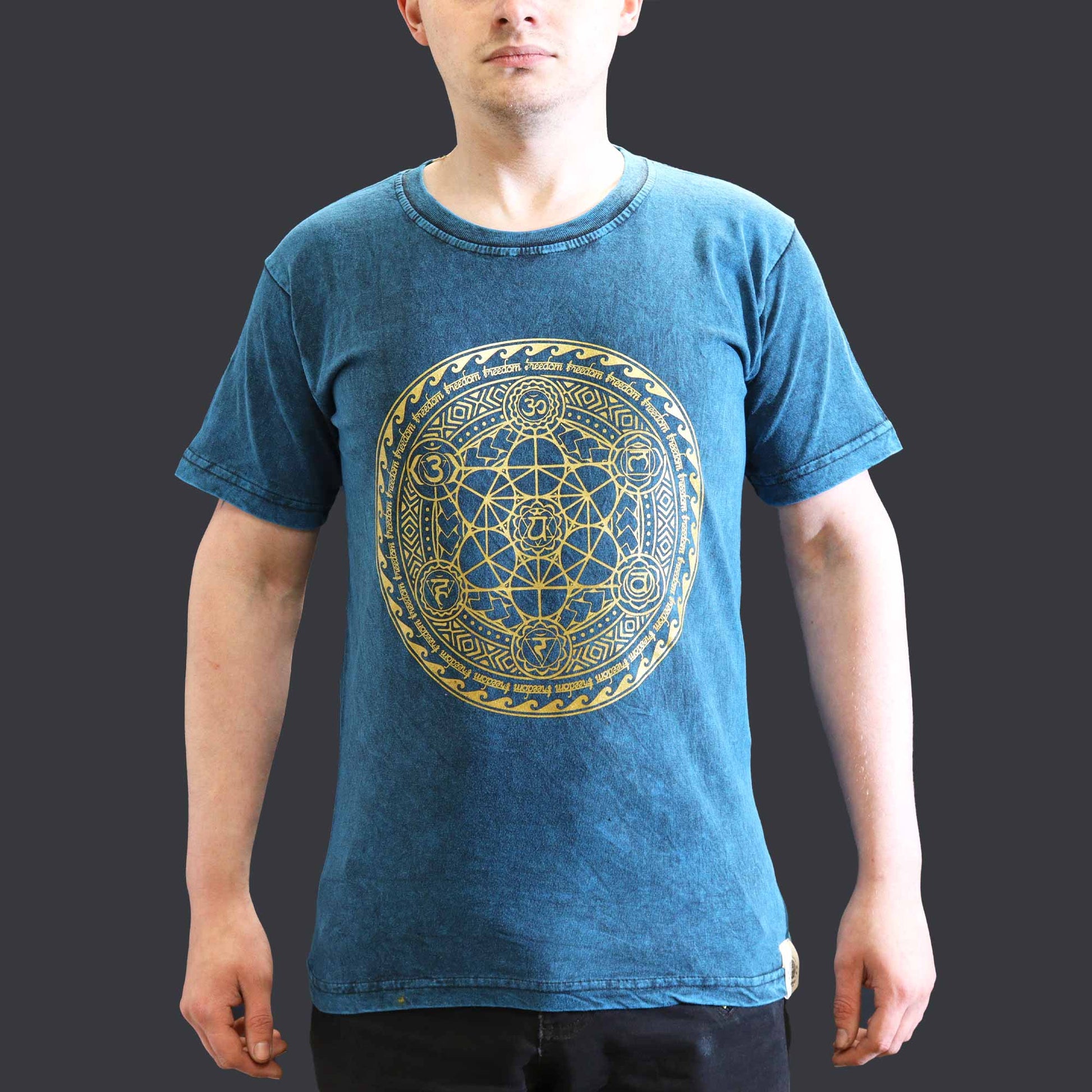 Person wearing a blue t-shirt with a gold geometric Chakra  design on a plain background