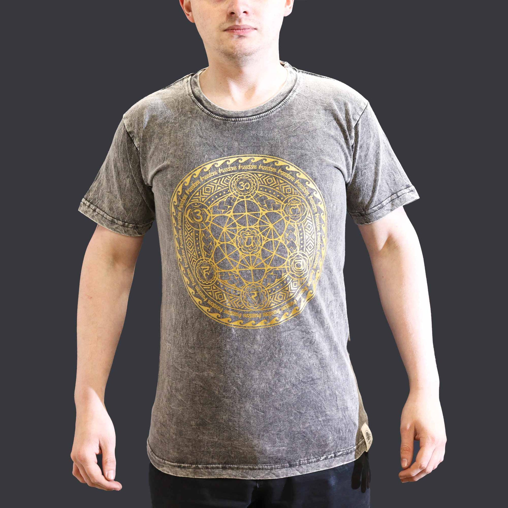 Front view of Person wearing a gray t-shirt with a gold geometric Chakra  design on a dark grey background