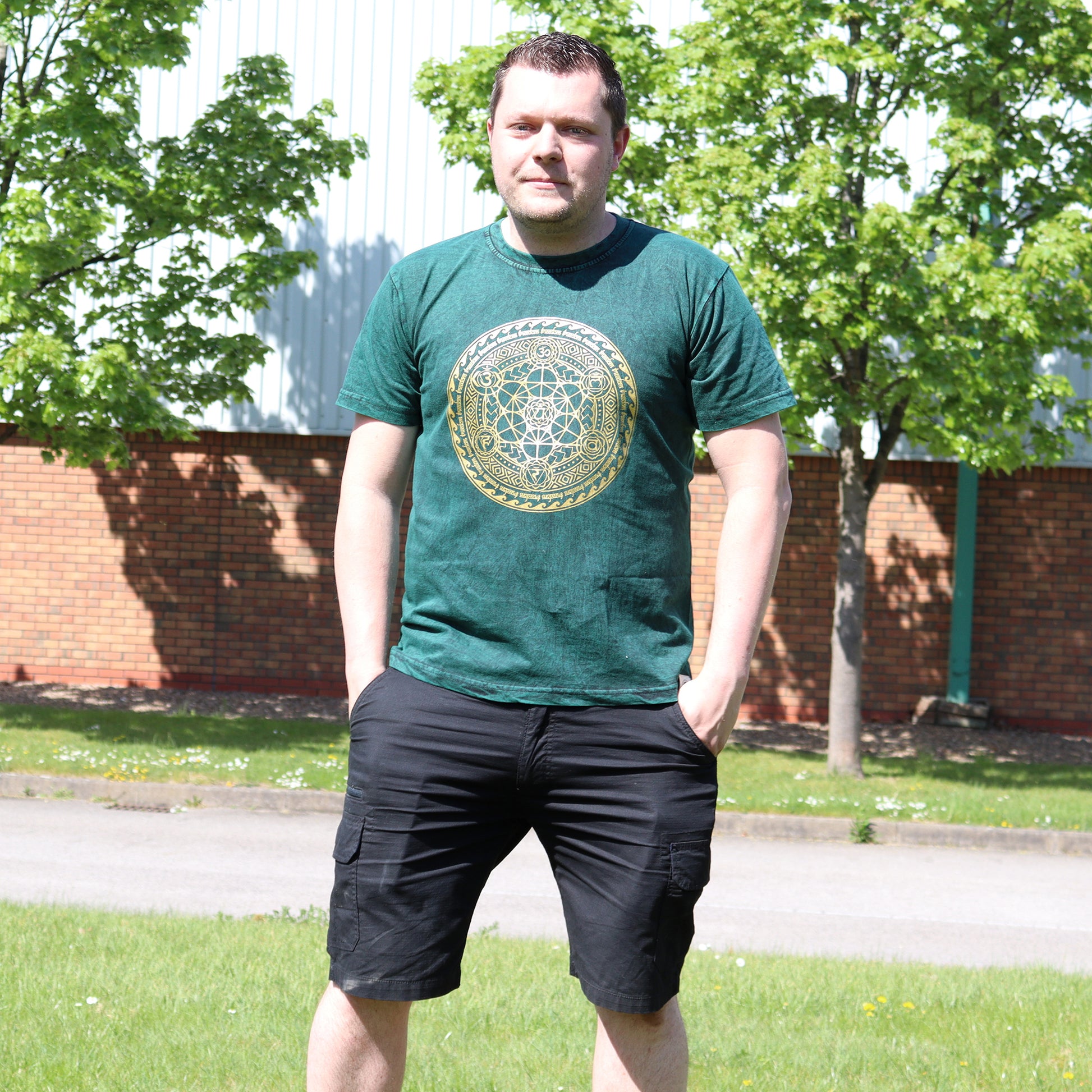 Man wearing a green t-shirt with a geometric design outdoors