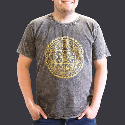 Person wearing a gray t-shirt with a gold geometric design on a plain background