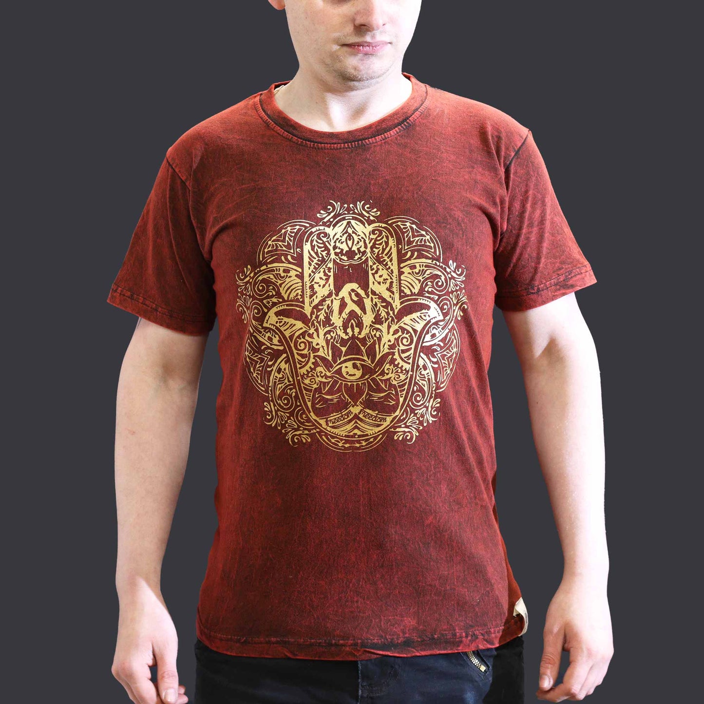 Red t-shirt with gold  hamsa intricate design worn by a person on a dark background