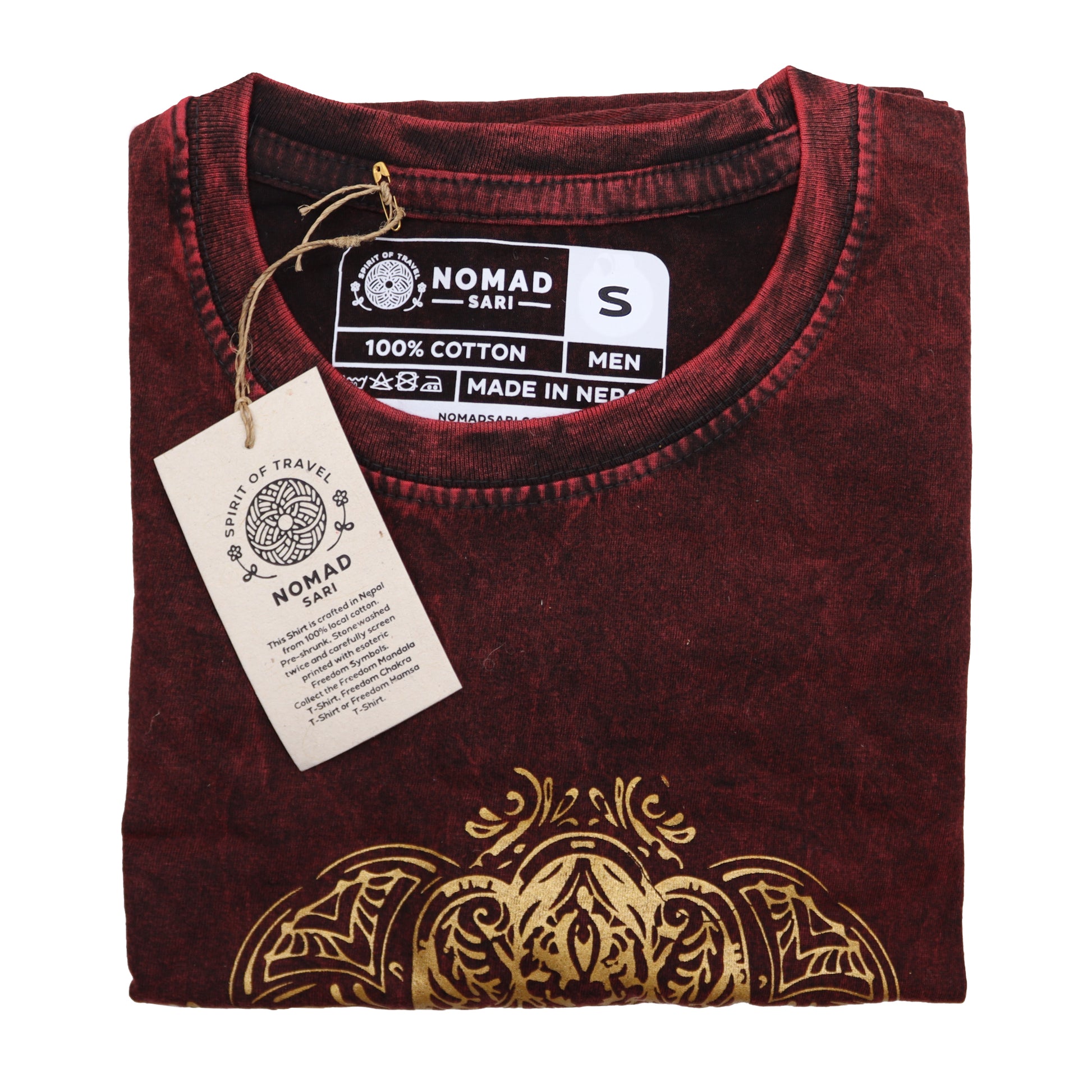 Folded maroon t-shirt with gold design and Nomad label on a white background