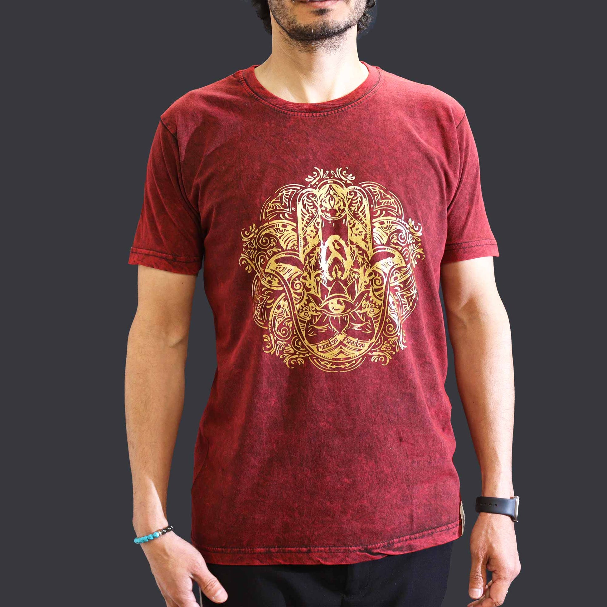 Red t-shirt with gold graphic design worn by a person on a dark background
