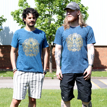 Two men wearing blue t-shirts with a gold Hamsa emblem design outdoors.