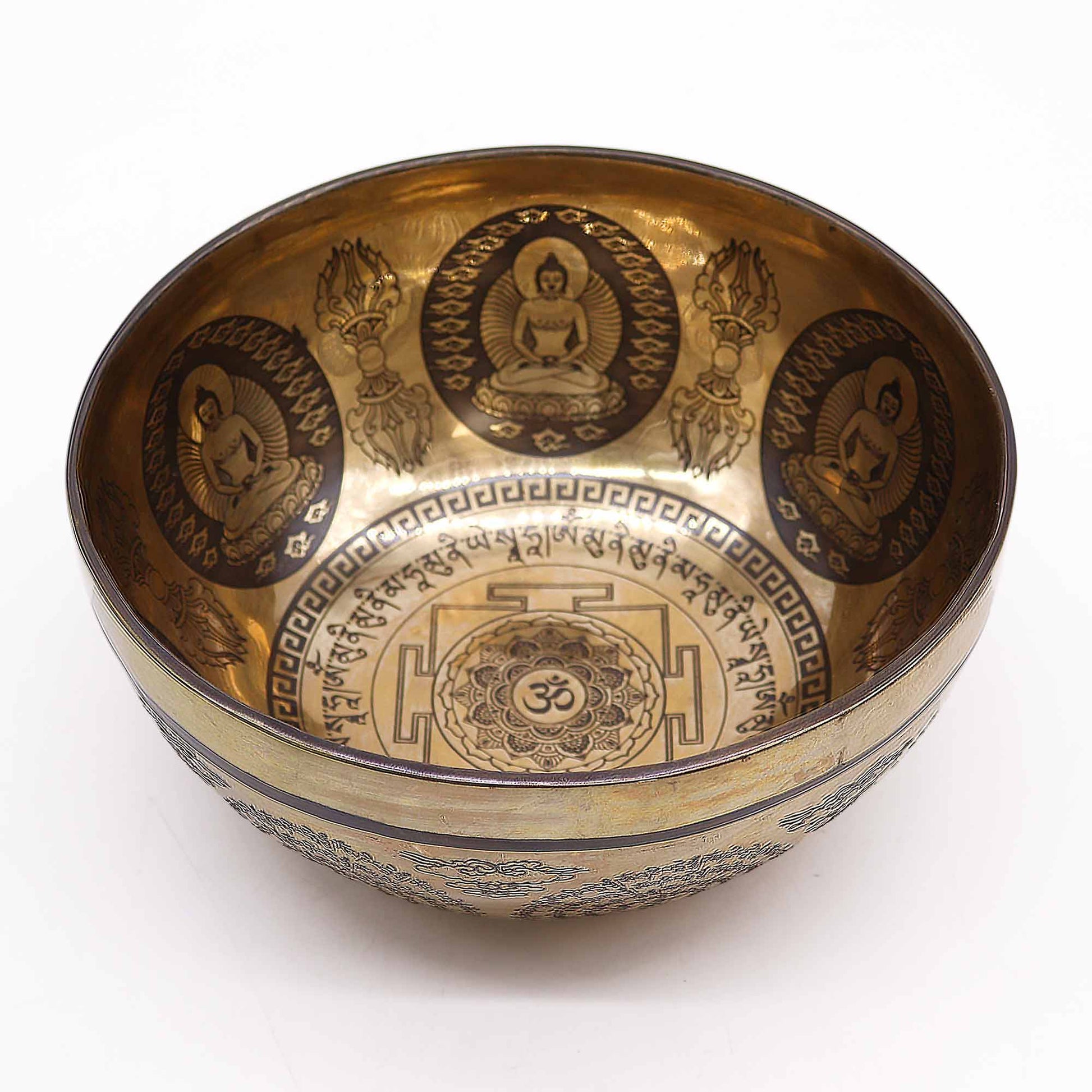 An engraved Tibetan singing bowl with intricate designs and symbols representing the 7 chakras, predominantly in a bronze or brown color.Underground Allure, Essex UK