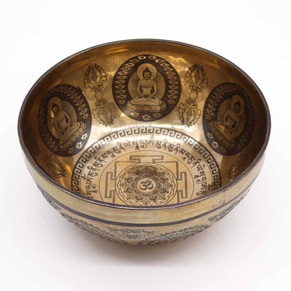 An engraved Tibetan singing bowl with intricate designs and symbols representing the 7 chakras, predominantly in a bronze or brown color.Underground Allure, Essex UK
