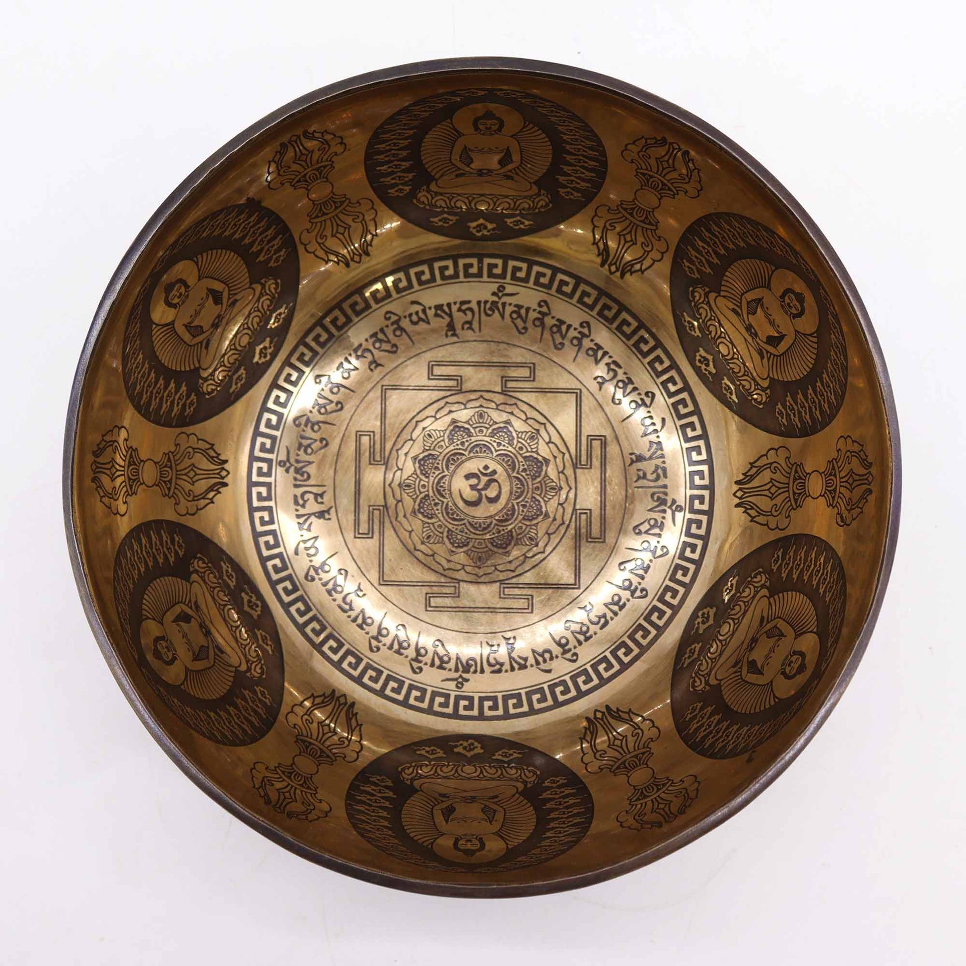 An engraved Tibetan singing bowl with intricate designs and symbols representing the 7 chakras, predominantly in a bronze or brown color.Underground Allure Essex, UK