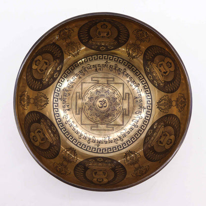 An engraved Tibetan singing bowl with intricate designs and symbols representing the 7 chakras, predominantly in a bronze or brown color.Underground Allure Essex, UK