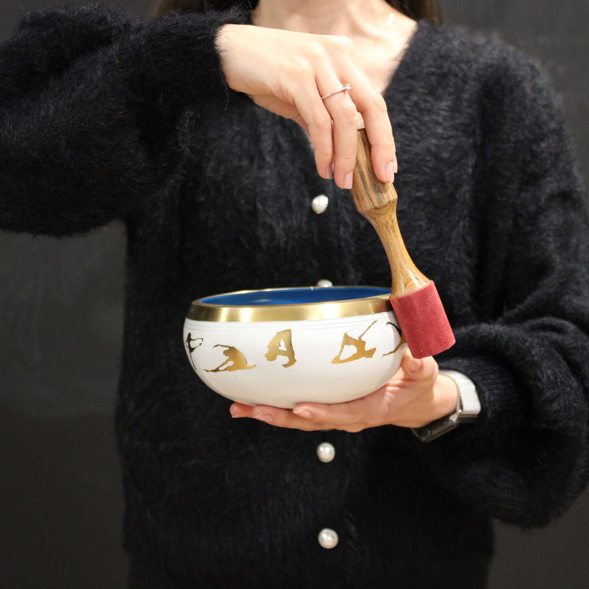A woman using her Lrg Buddha Singing Bowl Set- Black/Orange 14cm