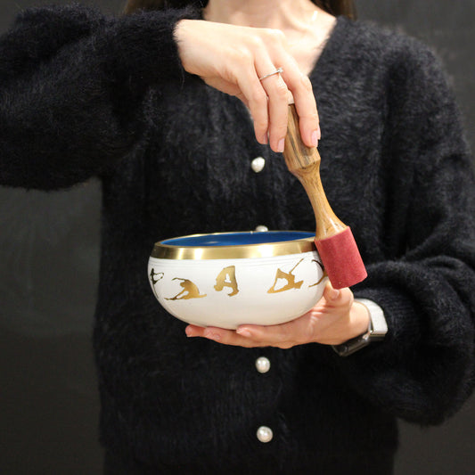 A woman using her Lrg Buddha Singing Bowl Set- Black/Orange 14cm
