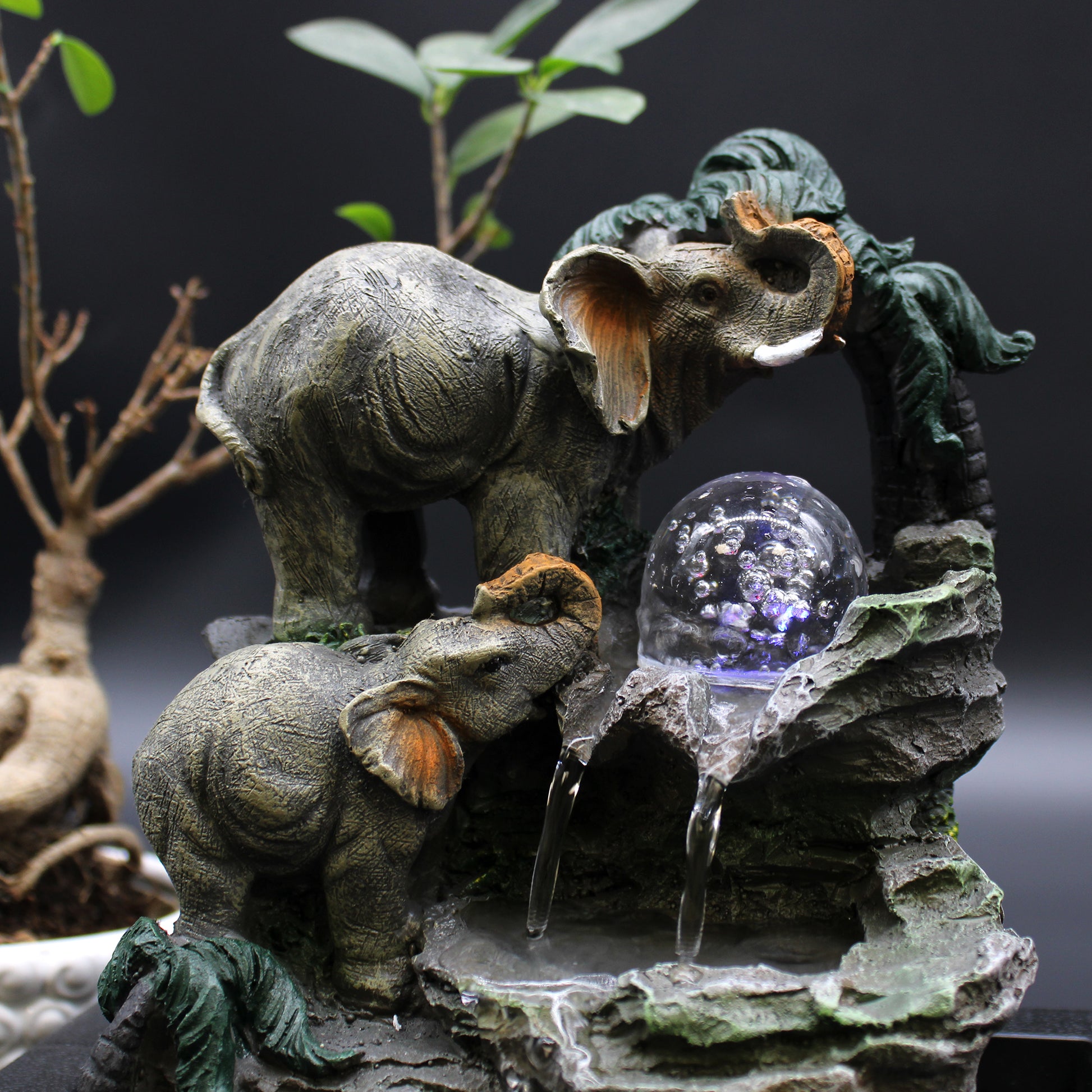 Close-up Tabletop Water Feature - 30cm - Elephant Family with a crystal ball on a rocky base.