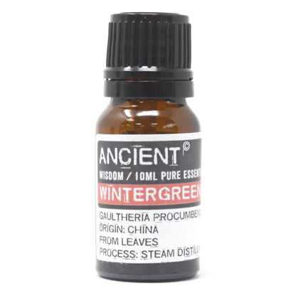 A bottle of Ancient Wisdom Wintergreen Essential Oil, indicating a volume of 10ml and that the oil is derived from leaves. The label also notes that the product is sourced from China and uses steam distillation for extraction.