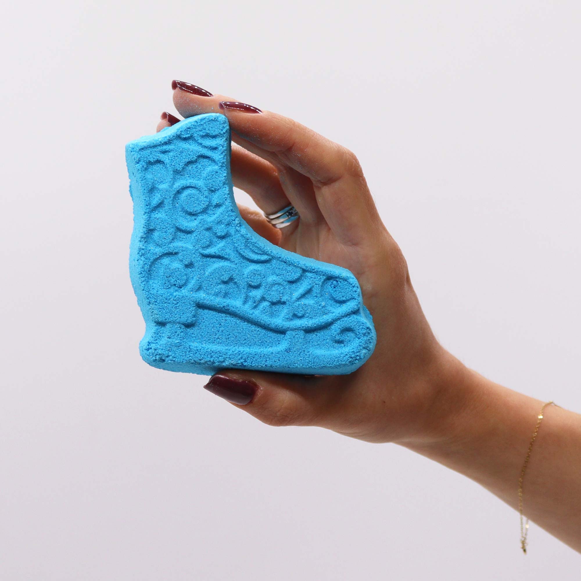 female hand holding a piece of blue soap