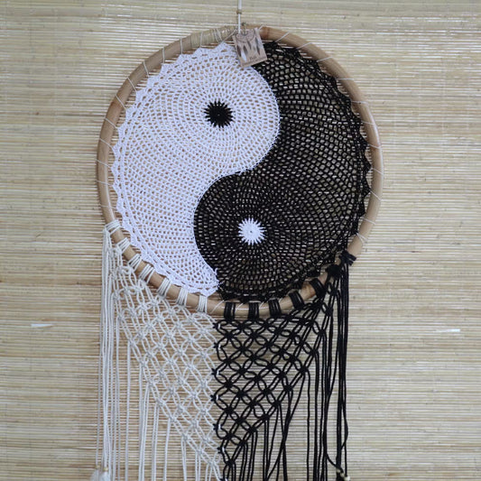 Dreamcatcher with yin yang design on a woven background